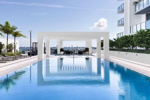 Une piscine moderne offrant une vue dégagée sur les gratte-ciel de la ville en arrière-plan.