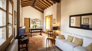 Un salon chaleureux avec une cheminée, un téléviseur, un canapé et un coin repas comprenant une table et des chaises.