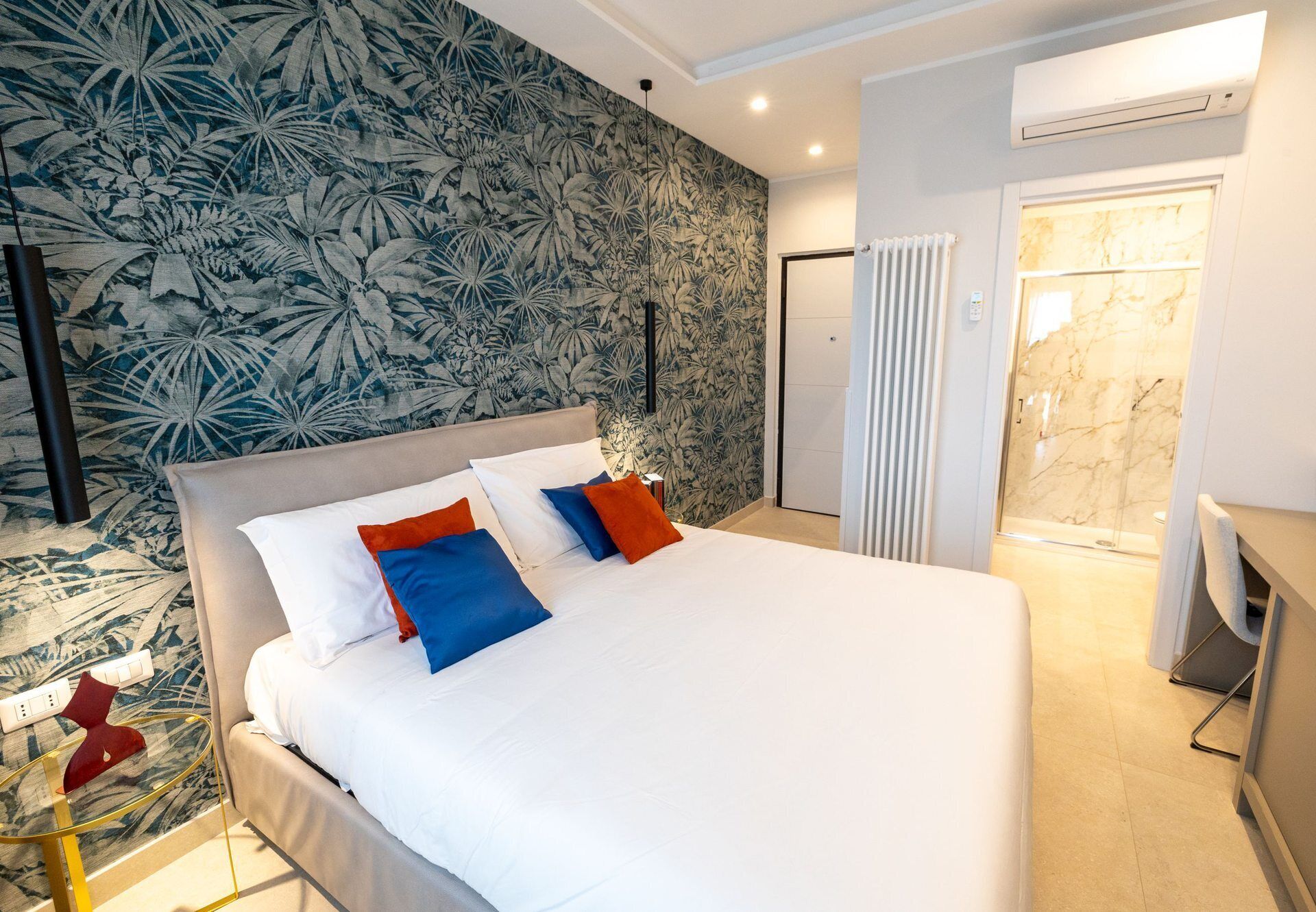A hotel room with a large bed, a shower, and a marble wall.