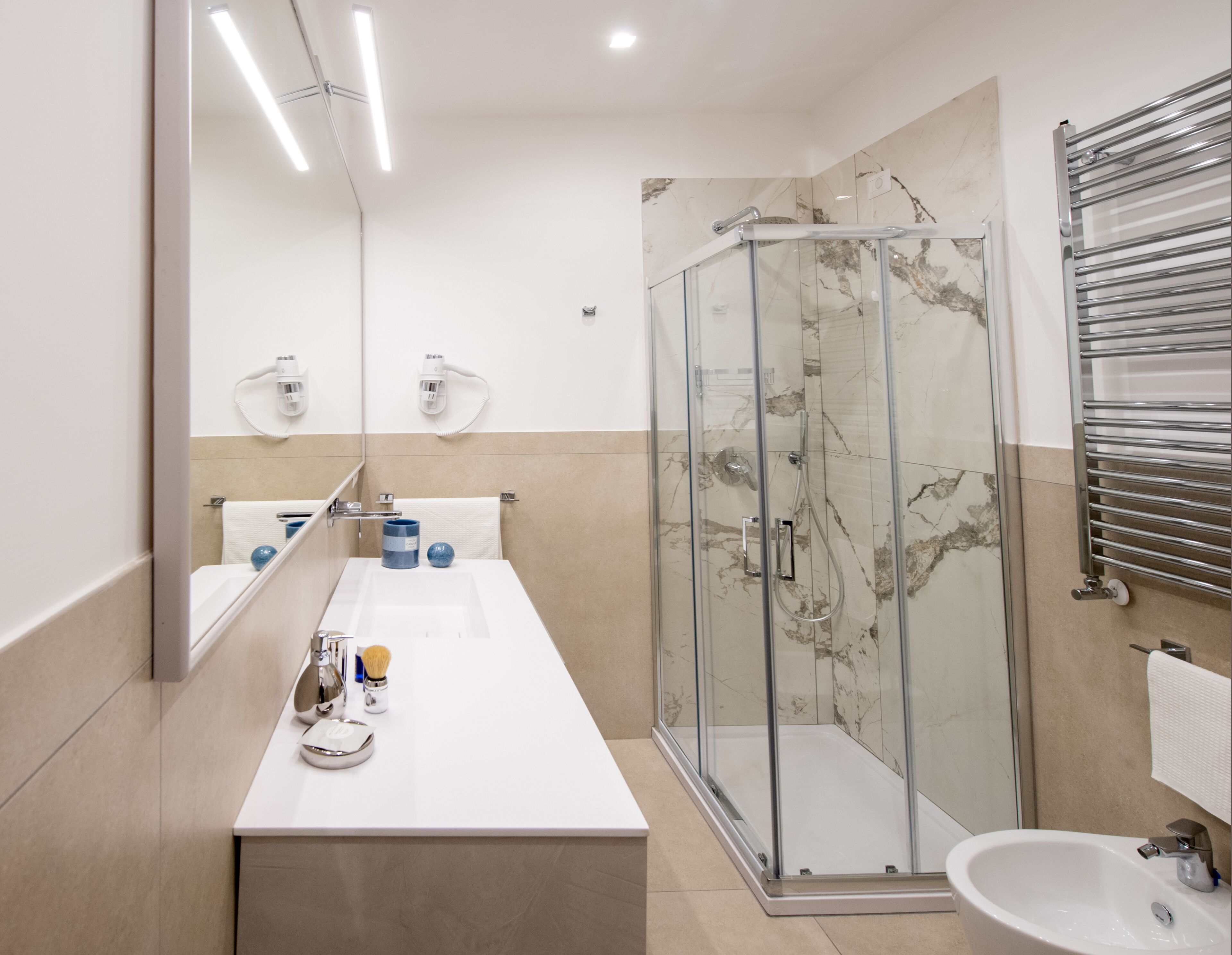 A modern bathroom with a glass-enclosed shower, a white sink, and a mirror.