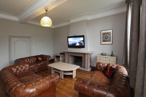 Relax in a classic living room with a comfortable sofa, coffee table, and brick fireplace.