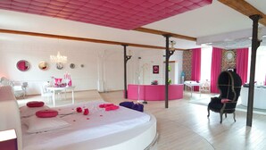 Una habitación moderna con una cama redonda, un tocador y una silla.