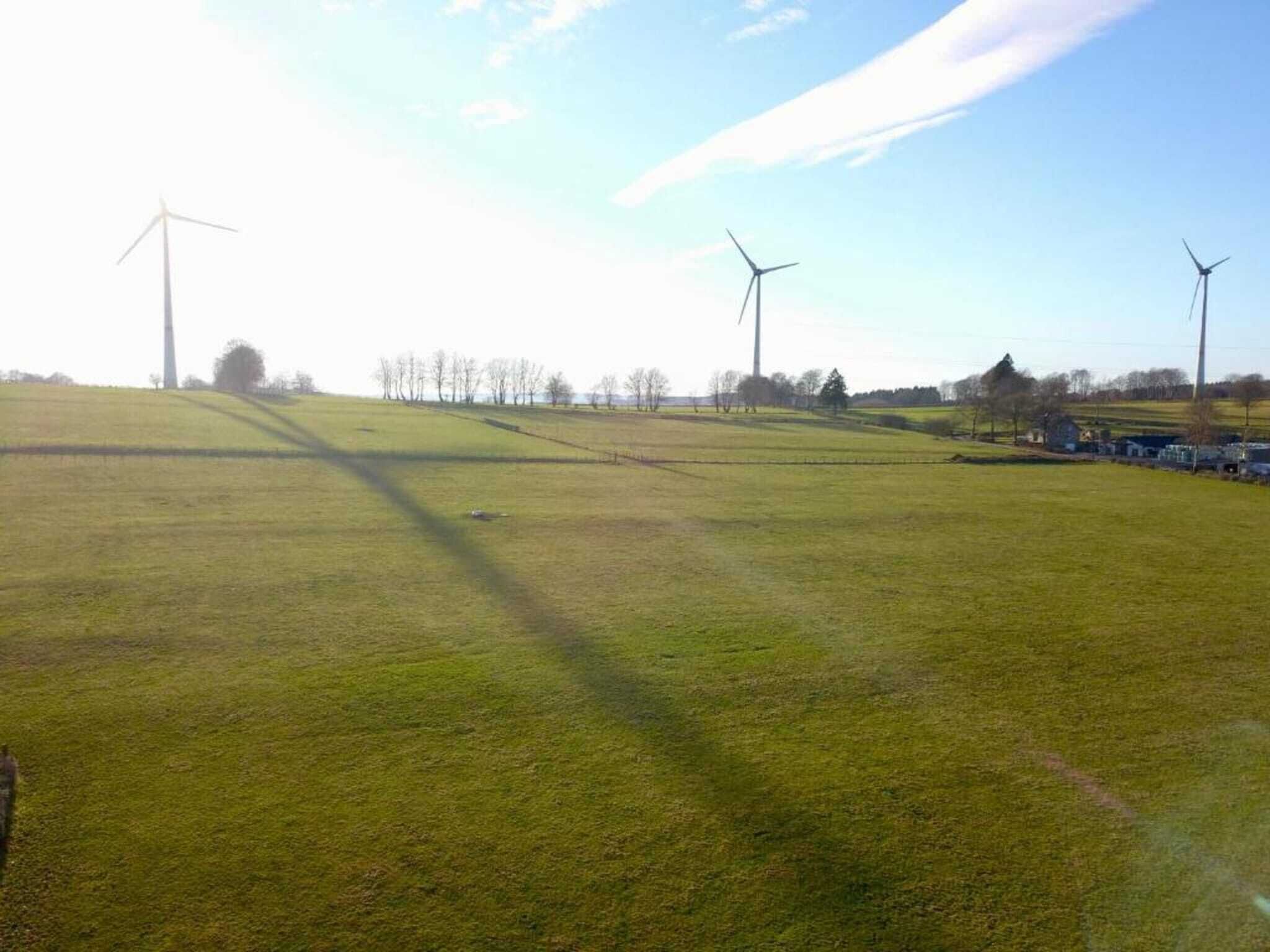 Un paysage rural avec des éoliennes et de vastes champs.
