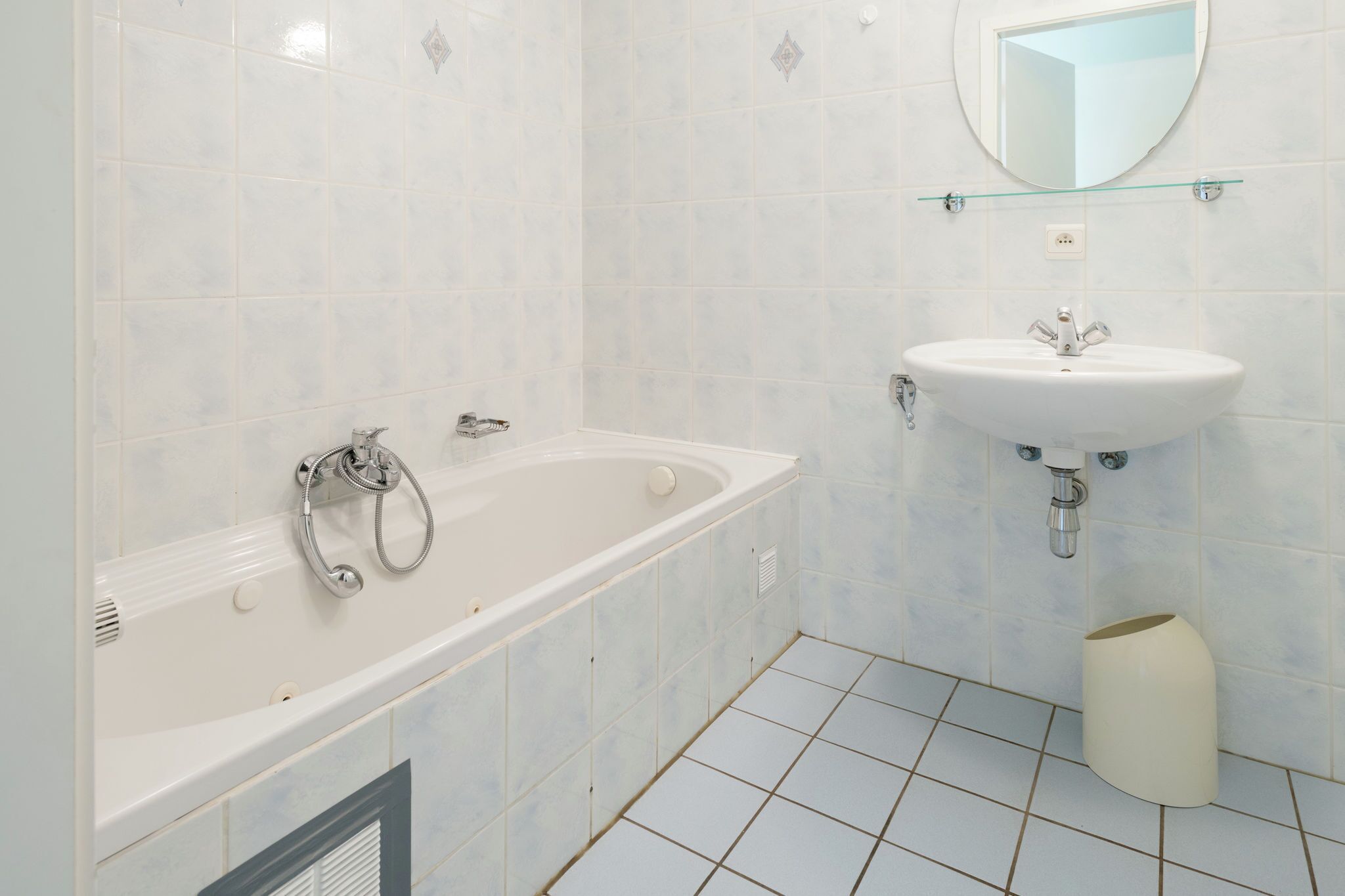 A modern bathroom with a bathtub, a sink, and a mirror.