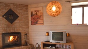 A cozy living room with a fireplace, a television, and a wooden table.