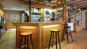 A bar area with stools, a counter, and various bar equipment.