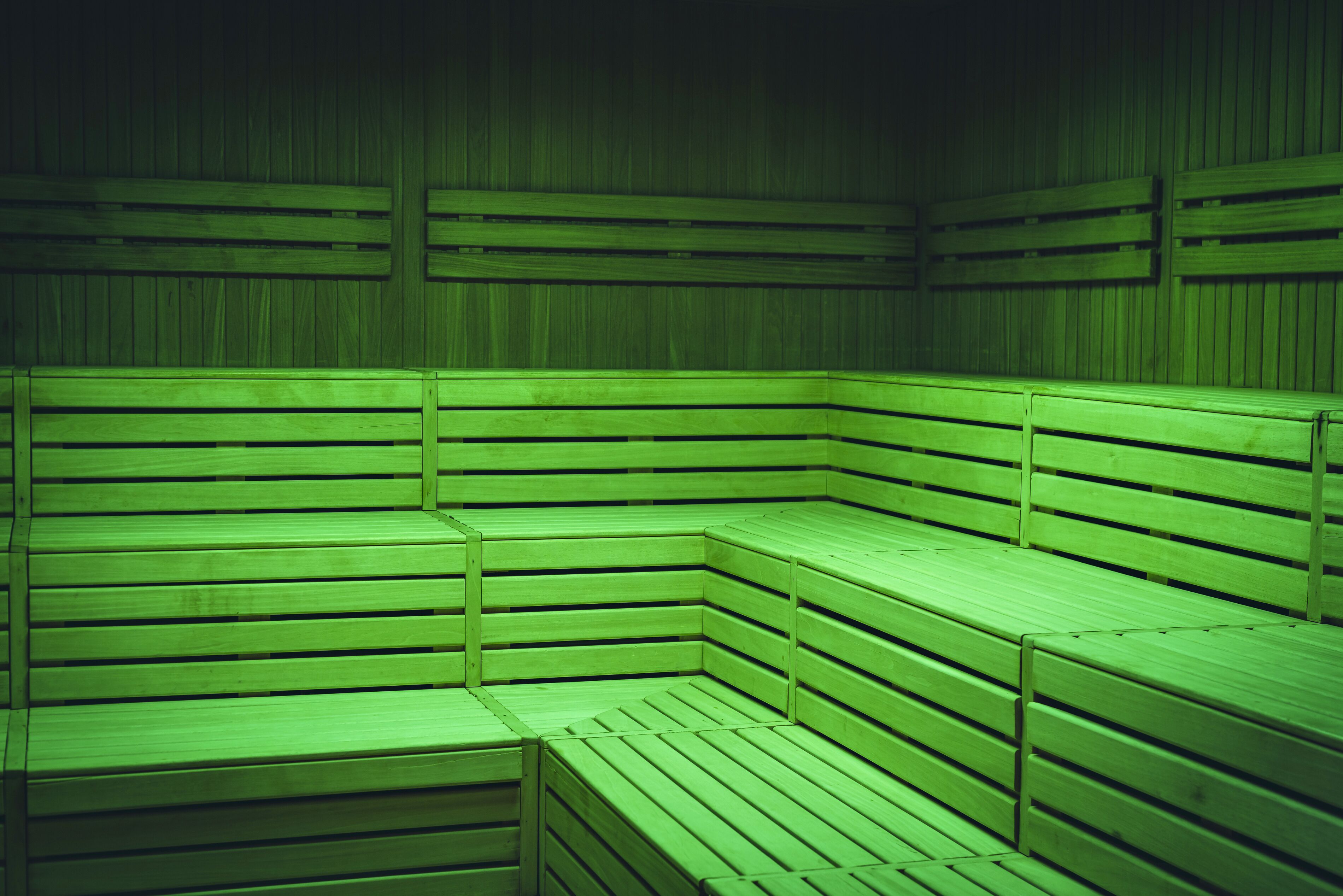 A sauna with wooden benches arranged in a corner.
