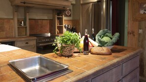 Une cuisine dotée d’un plan de travail en bois, d’un évier en acier inoxydable, d’un réfrigérateur et d’une cuisinière.
