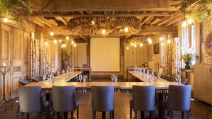Une salle de conférence équipée d’une longue table, de chaises et d’un écran de projection.