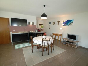 A compact living space with a kitchen, dining area, and a TV.