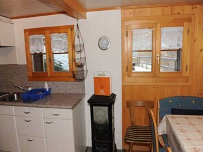 A kitchen with wooden cabinets, a sink, and a stove.