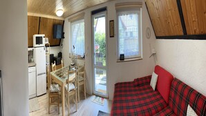 A compact living space with a kitchenette, a dining area, and a sofa.