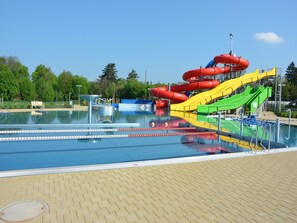 A swimming pool with multiple slides and a lifeguard tower. - Chalet in Malá Skála near Ski Slopes (Malá Skála)