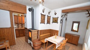Una habitación acogedora con estufa de leña, muebles de madera y cuernos de ciervo en la pared.
