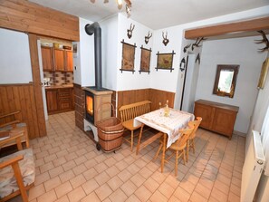 Une pièce chaleureuse avec un poêle à bois, des meubles en bois et des bois de cerf accrochés au mur.