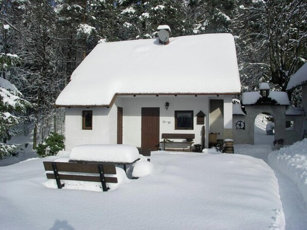 A small, snow-covered building with a wooden bench in front. - Chalet in Malá Skála near Ski Slopes (Malá Skála)