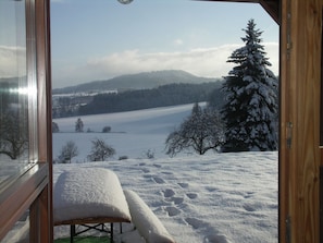 A snow-covered landscape with a bench and a wooden door. - Spacious Group Retreat (Dlouhý)