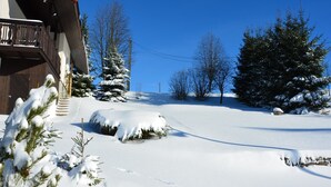 A snow-covered landscape with a wooden building, snow-covered trees, and a clear blue sky. - Spacious cottage in the Giant Mountains, 1 km from the skislopes (Jestřabí V Krkonoších)