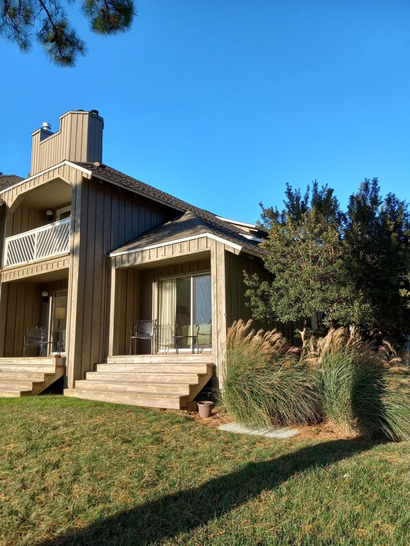 A two-story wooden house with a balcony, a covered porch, and a chimney. - Walk to beach, cozy, lovely room in "Kingsmill on the James" (Williamsburg)
