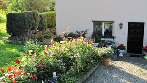 A house with a well-maintained garden, a paved driveway, and a black door. - Tranquil Stay in Dörnthal (Pfaffroda Ot Dörnthal)