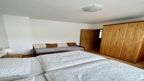 Un dormitorio con una cama, un armario y una mesita de noche.