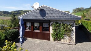 Un petit bâtiment doté d’un toit en pente, d’une antenne parabolique et d’une fenêtre avec des rideaux.