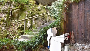 A rustic outdoor area with a wooden structure, a stone staircase, and a decorative figure. - Ferienwohnung in Schiltach (Schiltach)