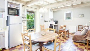 A cozy kitchen with a dining table, chairs, and a built-in oven. - Cottage in Oppède with Poolside Bliss (Oppède)