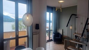 Ein modernes Wohnzimmer mit einem großen Fenster, einer Kristallleuchtre und einer Treppe.