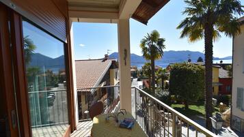 Ein Balkon mit Tisch, Blick auf eine Stadt und ein Berg im Hintergrund.