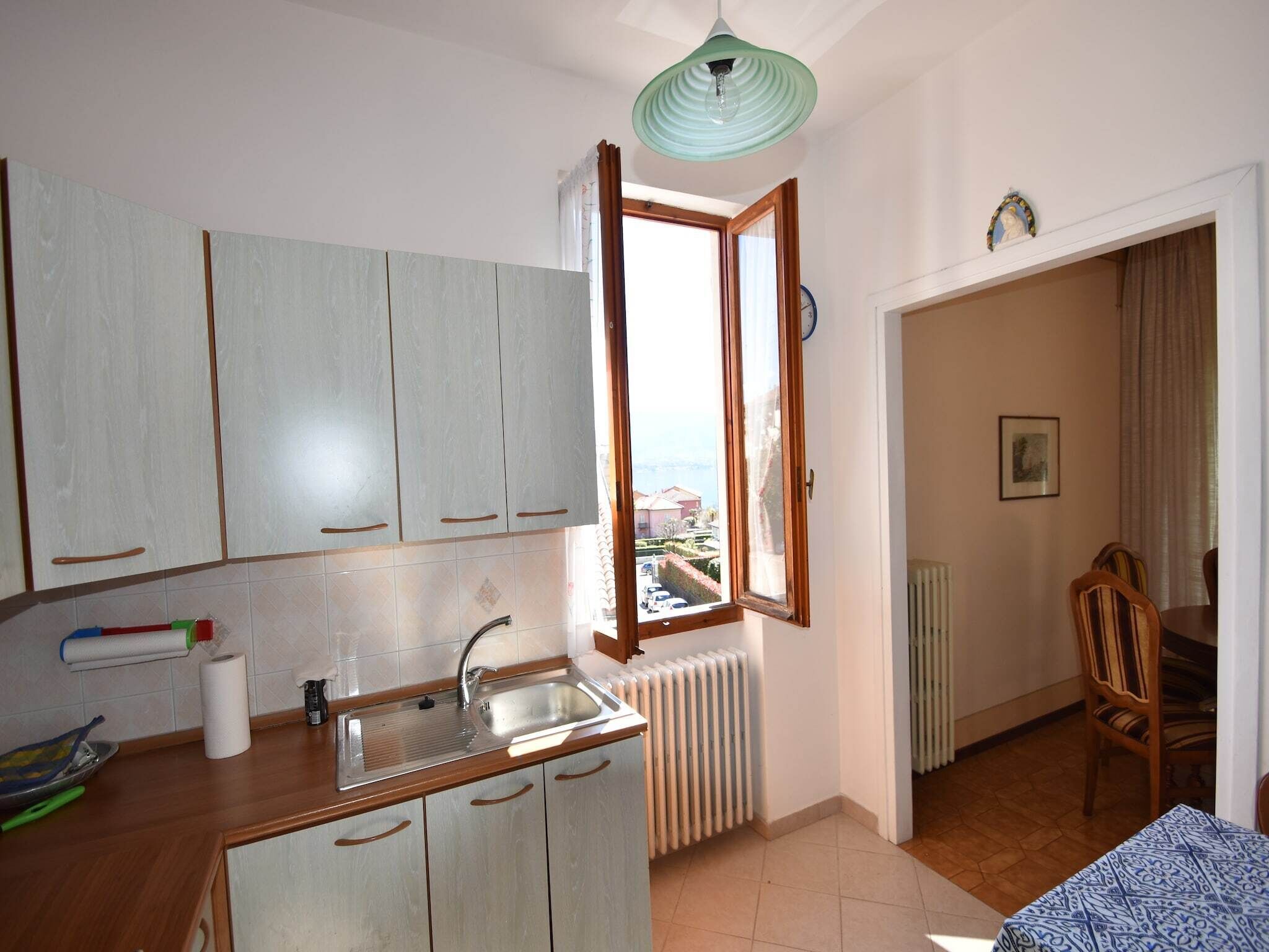 Eine Küche mit Fenster, Heizkörper und einem Essbereich mit Stühlen.