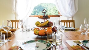 A dining table set with plates, glasses, and a fruit stand. - Villa with private swimming pool (Tredozio)