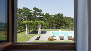 A view of a swimming pool with lounge chairs and a pergola, surrounded by trees and a stone pathway. - Villa with private swimming pool (Tredozio)