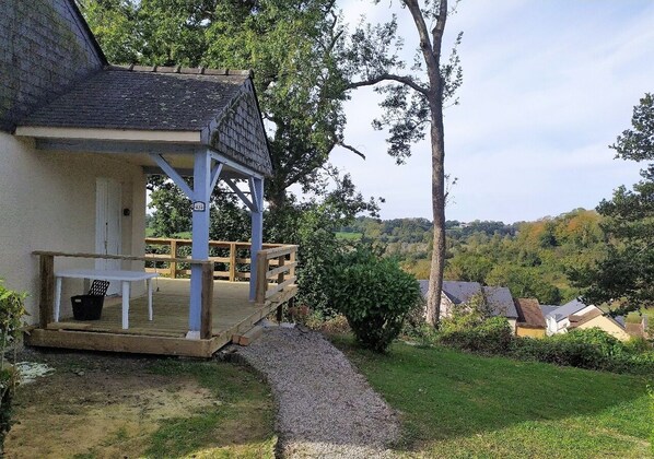 A house with a porch, a table, and a chair.