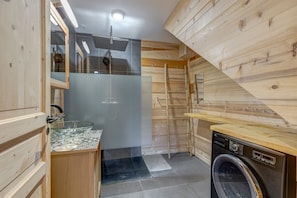 A compact kitchen with a glass sink, wooden cabinets, and a washing machine. - Le Chalet Blanc - Magnifique chalet sur les pistes (La Giettaz)