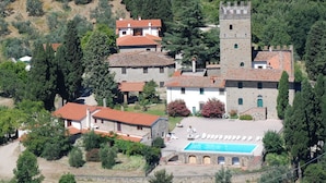 Un village traditionnel avec des bâtiments en pierre, une tour et une piscine.