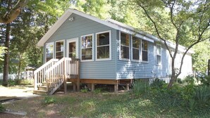 A single-story house with a front porch and a staircase leading to the entrance. - Restored 1920's peaceful, lakeside cottage (Pullman)