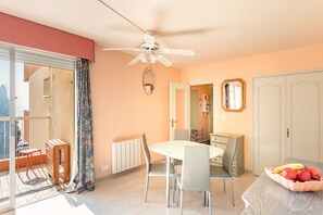 A dining area with a table, chairs, a ceiling fan, and a fruit bowl. - Saint-Raphaël, Peguière Beach (Saint Raphäel)