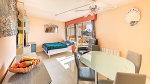 A compact hotel room with a bed, a dining table, a ceiling fan, and a fruit bowl. - Saint Raphael plage Peguiere (Saint Raphäel)