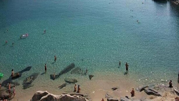 A beach with clear water, rocks, and people swimming. - Villa in Lonnano with pool (Lonnano)