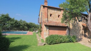 A stone building with a tiled roof, a swimming pool, and a well-maintained lawn. - Villa with Pool and Wine Country Charm (Arezzo)