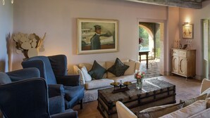 A living room with a sofa, armchairs, a coffee table, and a painting on the wall. - Villa with Pool and Wine Country Charm (Arezzo)