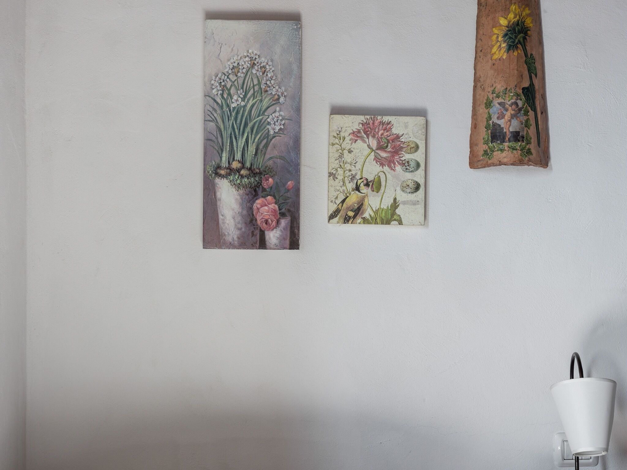 Three framed artworks on a plain wall.