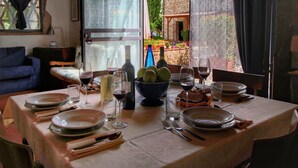 Une table à manger dressée pour quatre personnes, avec des verres à vin, des assiettes et une bouteille de vin.