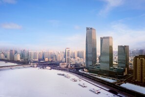 A cityscape with modern skyscrapers, a river, and a bridge.