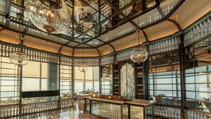 Un intérieur spacieux avec un plafond haut, de grandes fenêtres et un bar central.