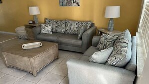A living room with a sofa, two side tables, a coffee table, and lamps. - King Suite on Canal (Saint James City)