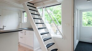 A kitchen with a white interior, a black countertop, and a white door. - Elegant Apartment in Hoorn with Roof Terrace (Hoorn)