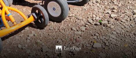 A row of go-karts parked on a gravel surface.