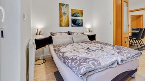 A bedroom with a bed, two wall-mounted lamps, and two abstract paintings. - Wohnung in Madfeld nahe Willingen Skilift (Brilon-Madfeld)